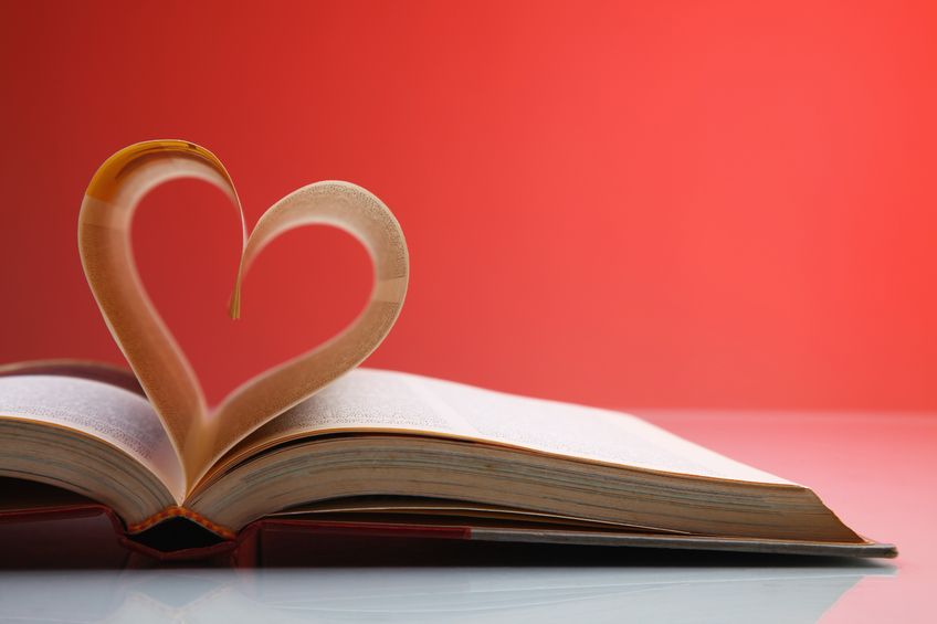 A book opened in the middle, with two pages curled up and forming heart