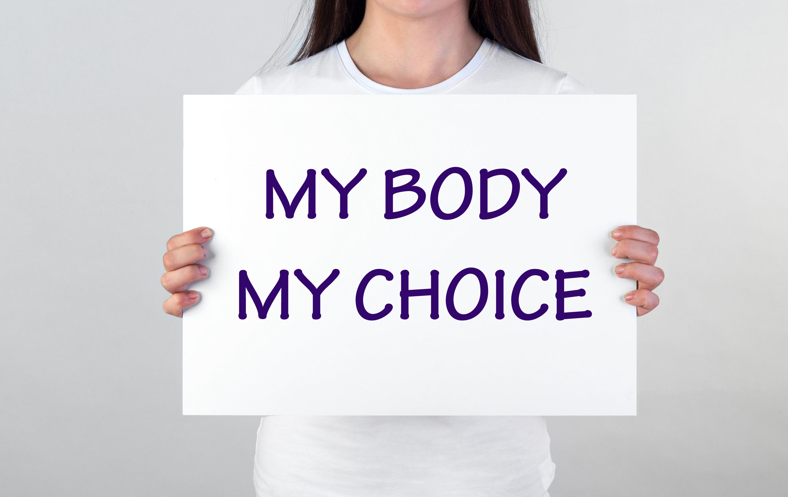 Woman holding placard that says "my body, my choice"