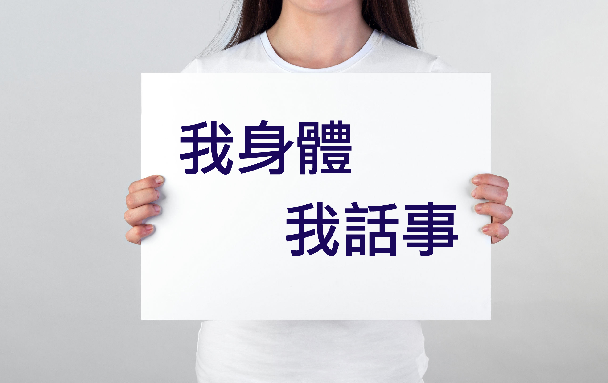 一名女子手持白色牌子，上面寫有六個字：我身體，我話事