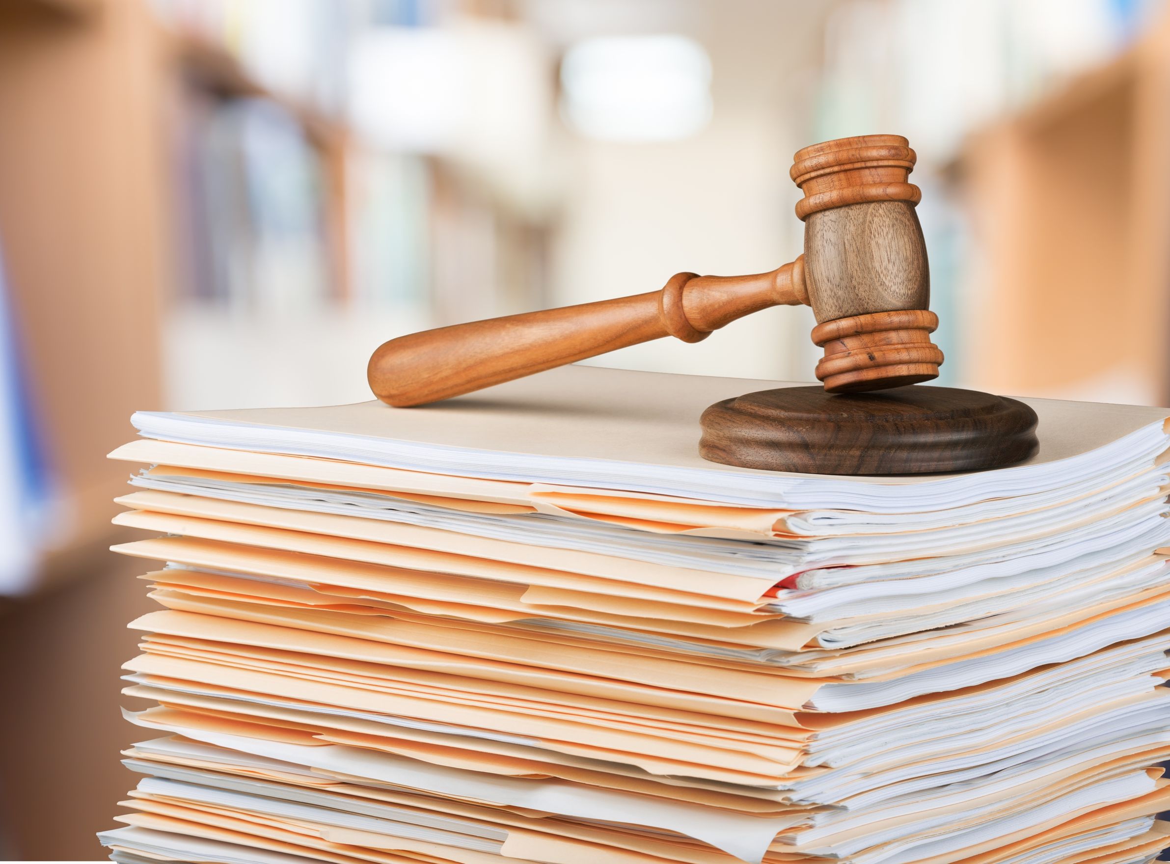 Photo of a gavel placed above a pile of documents