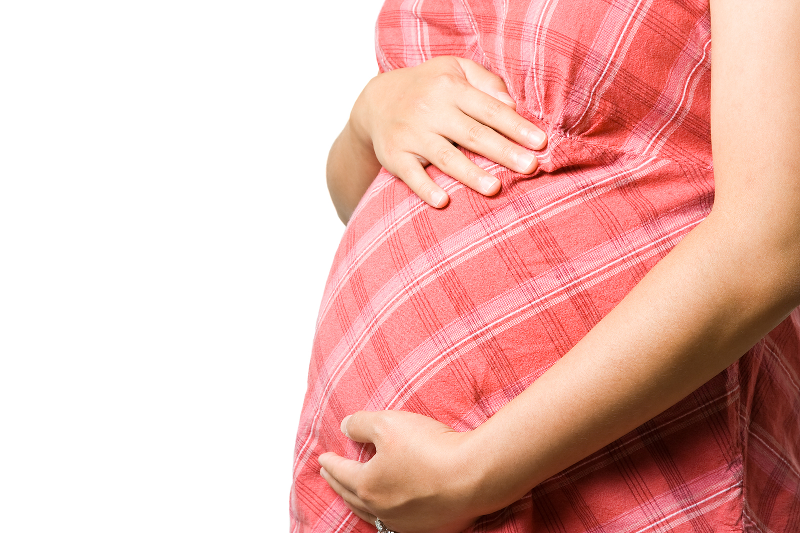 Close-up of pregnant woman in pink dress, gently putting her hands on her curved stomach Close-up of pregnant woman in pink dress, gently putting her hands on her curved stomach