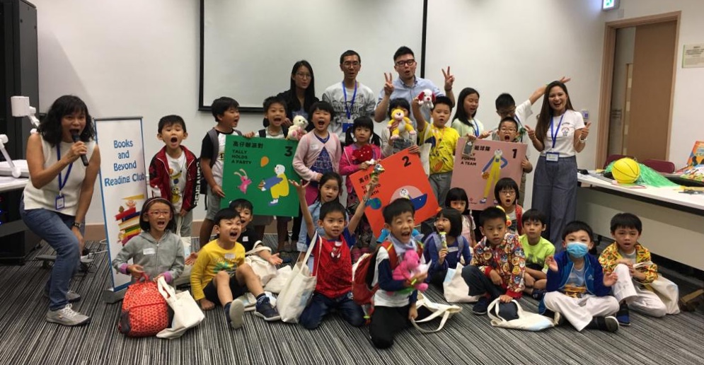 Children posing for a joyful group photo at the English Storytelling Workshop