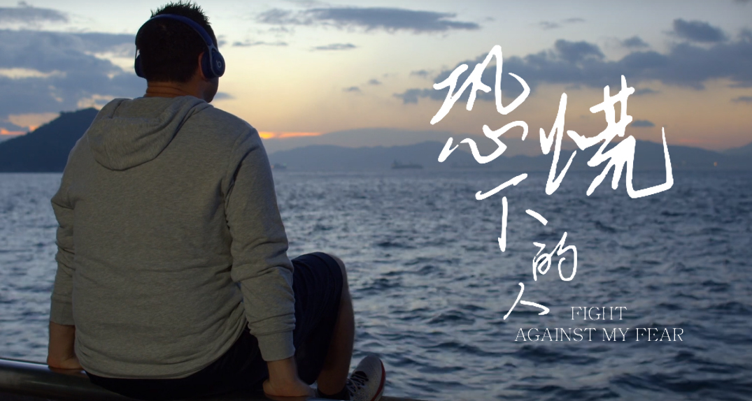 Film still showing the protagonist sitting alone by the sea Film still showing the protagonist sitting alone by the sea