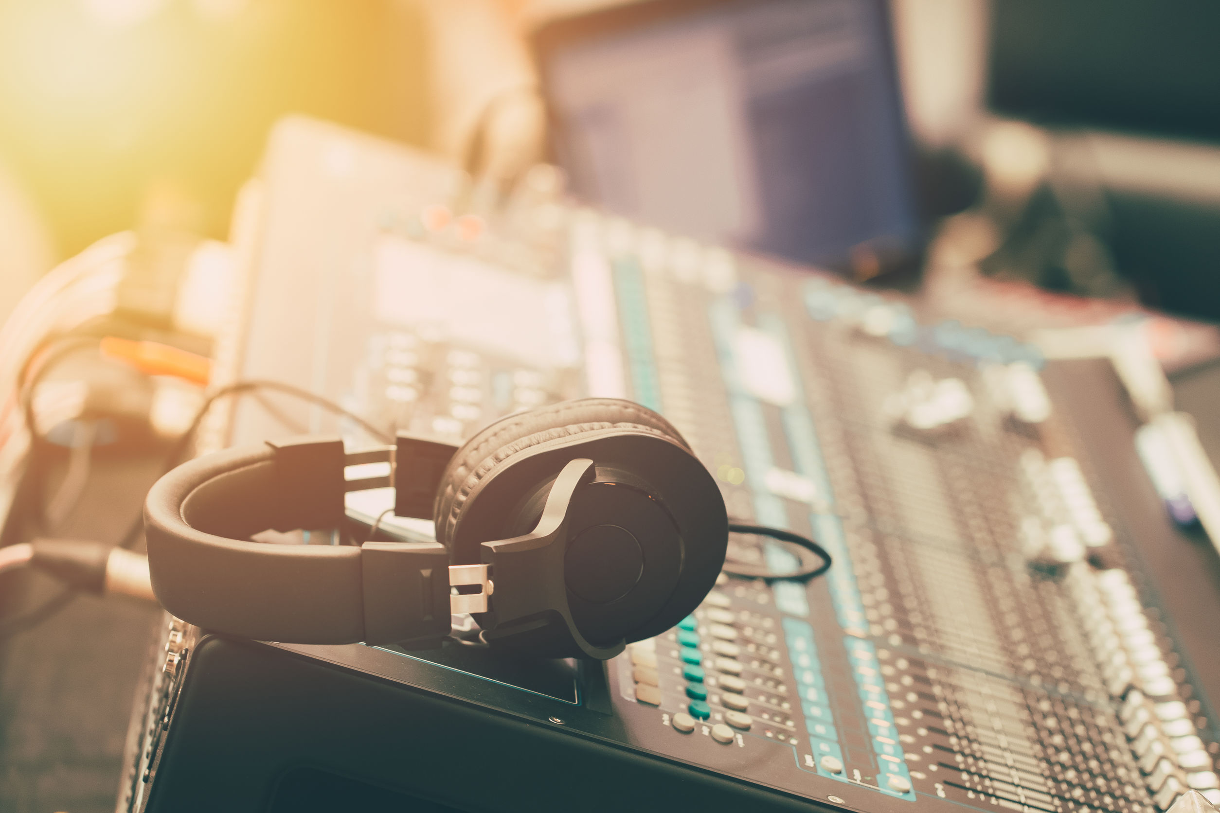 Photo of a control panel at a radio station studio, with a headphone lying on the panel.