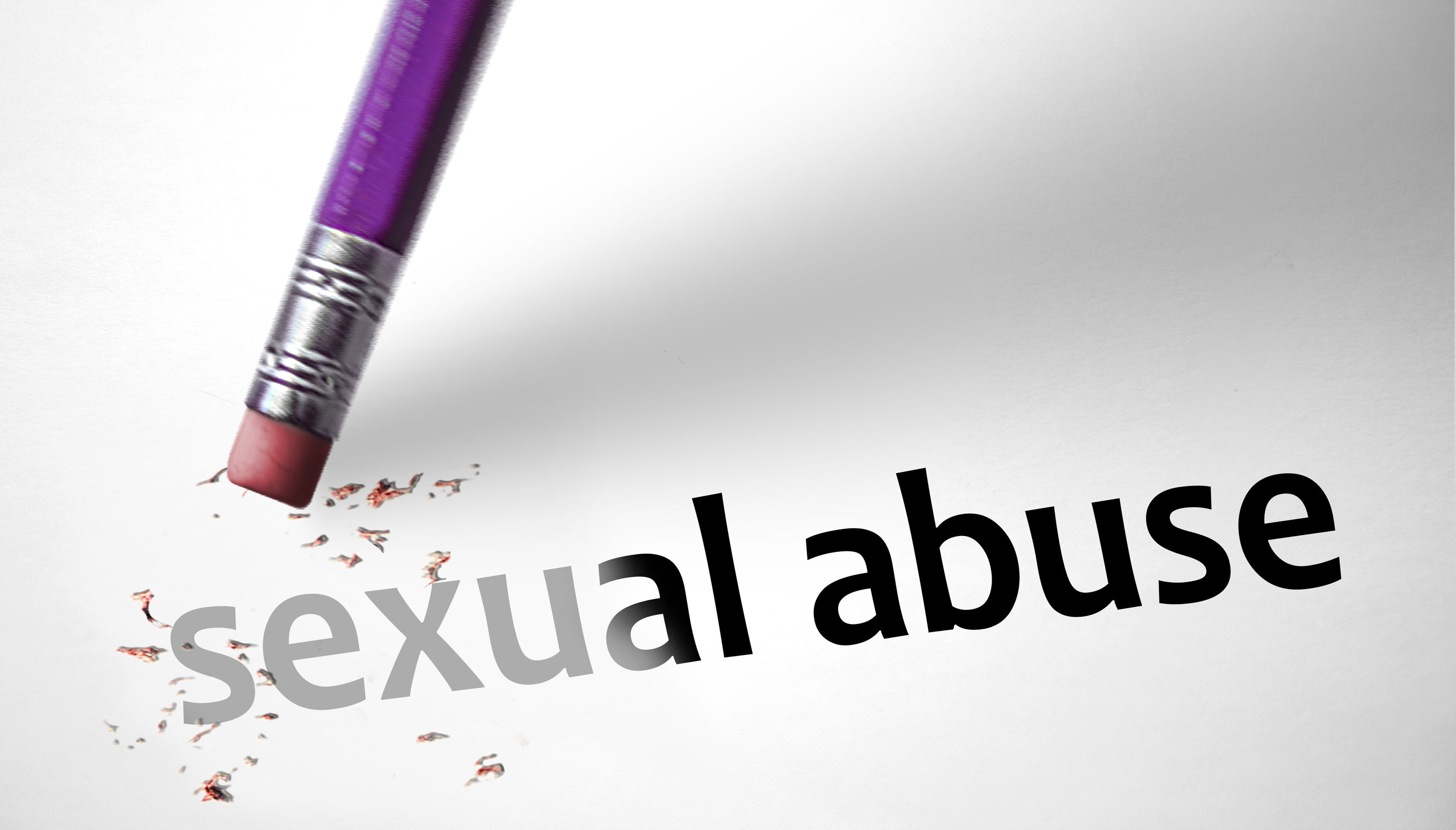 Image of an inverted pencil, with the eraser on its end rubbing away the text “sexual abuse”.