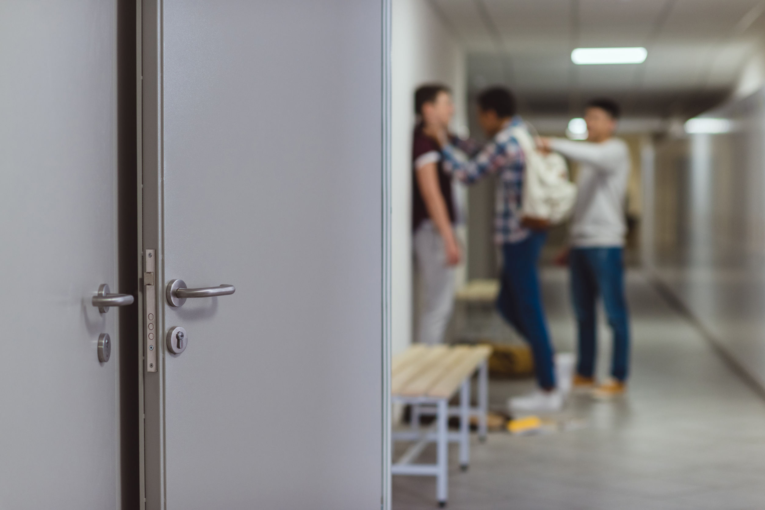 Blurred shot of a schoolboy being bullied by classmates in school corridor