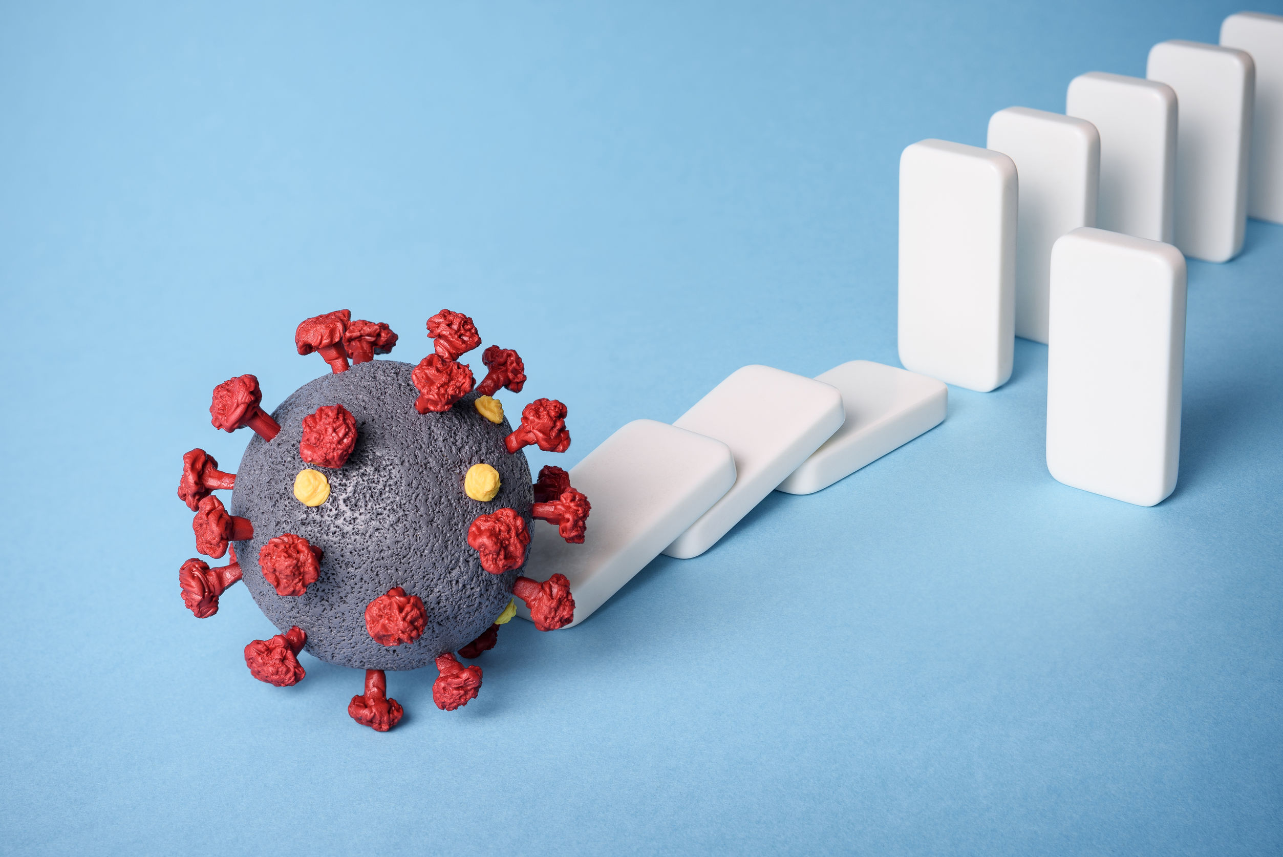 Photo of the coronavirus knocking down dominos Photo of the coronavirus knocking down dominos