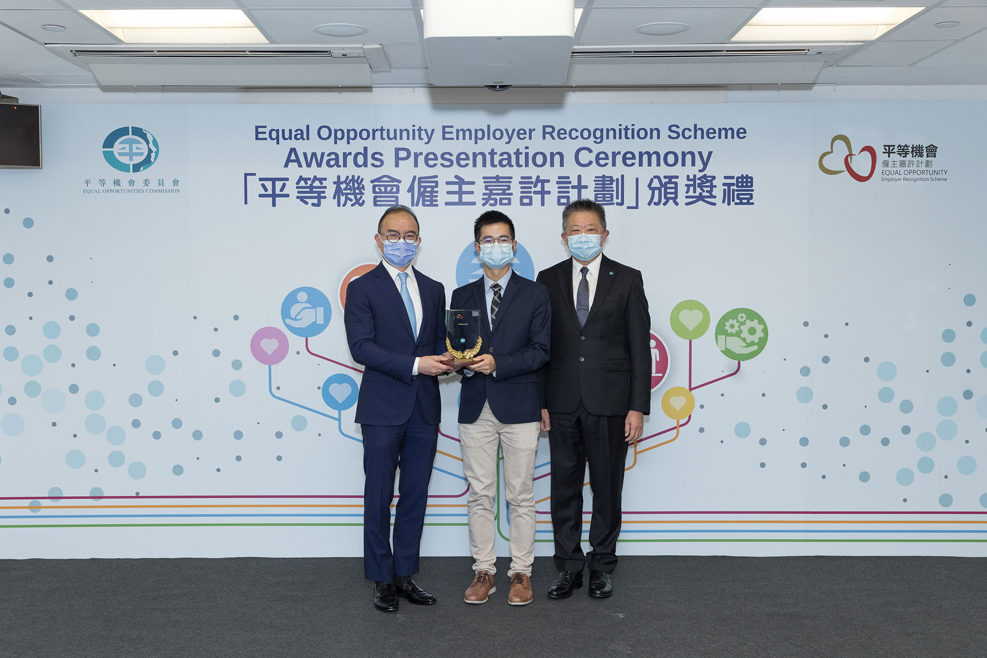 Mr Erick TSANG Kwok-wai, IDSM, JP, Secretary for Constitutional and Mainland Affairs (left) and Mr Ricky CHU Man-kin, IDS, Chairperson of the Equal Opportunities Commission (right), present the trophy to the representative of China Aircraft Services Limited (centre), winner of the Gold Award of the Equal Opportunity Employer Recognition Scheme.