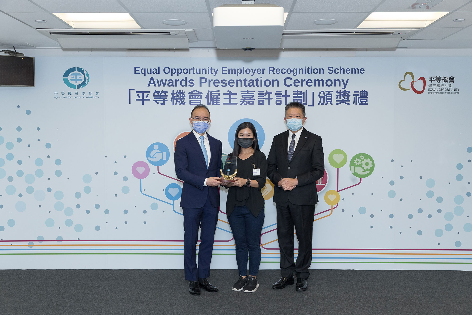 Mr Erick TSANG Kwok-wai, IDSM, JP, Secretary for Constitutional and Mainland Affairs (left) and Mr Ricky CHU Man-kin, IDS, Chairperson of the Equal Opportunities Commission (right), present the trophy to the representative of Eaton HK (centre), winner of the Gold Award of the Equal Opportunity Employer Recognition Scheme.