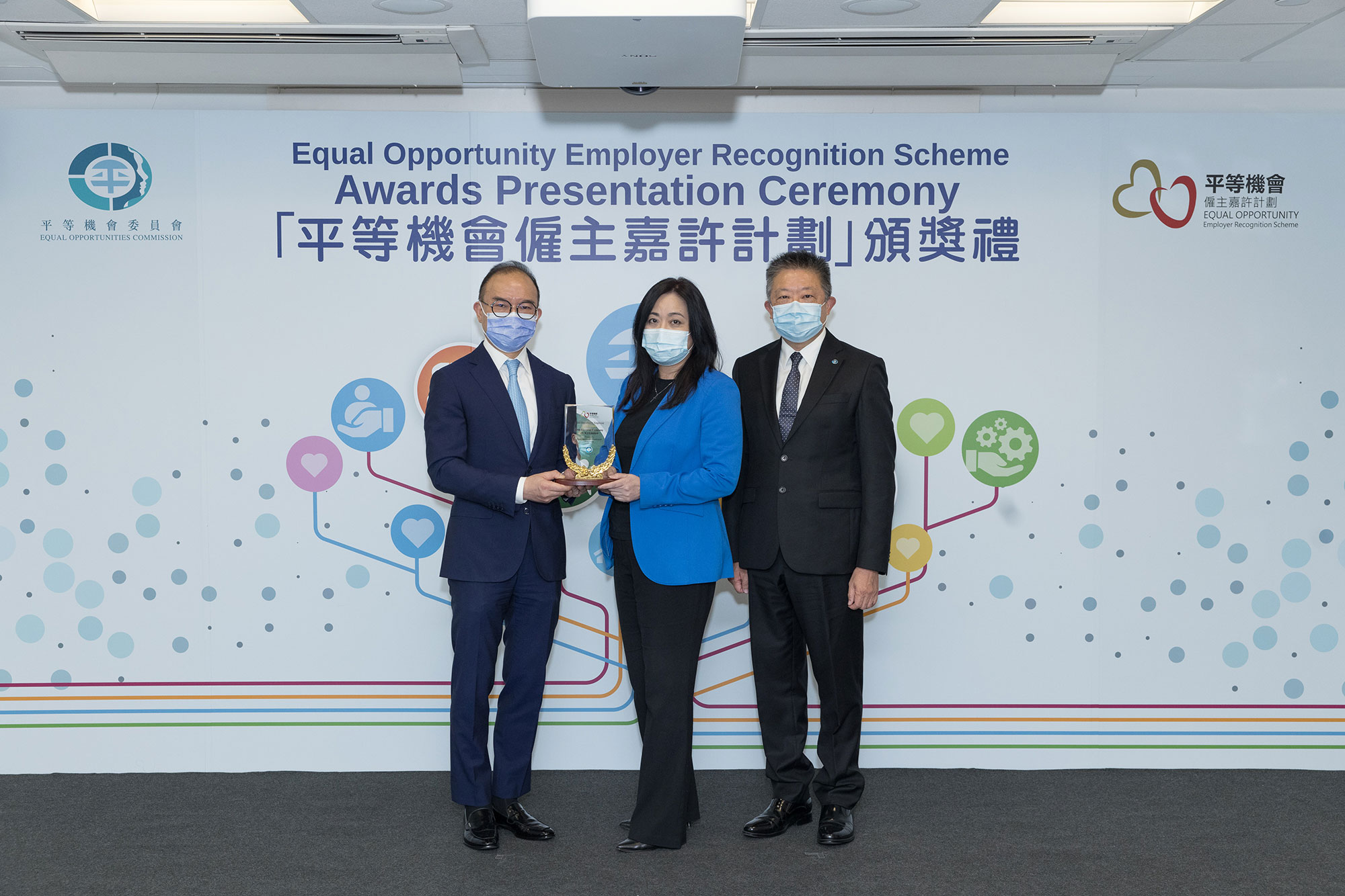 Mr Erick TSANG Kwok-wai, IDSM, JP, Secretary for Constitutional and Mainland Affairs (left) and Mr Ricky CHU Man-kin, IDS, Chairperson of the Equal Opportunities Commission (right), present the trophy to the representative of Otis Elevator Company (H.K.) Limited (centre), winner of the Gold Award of the Equal Opportunity Employer Recognition Scheme.
