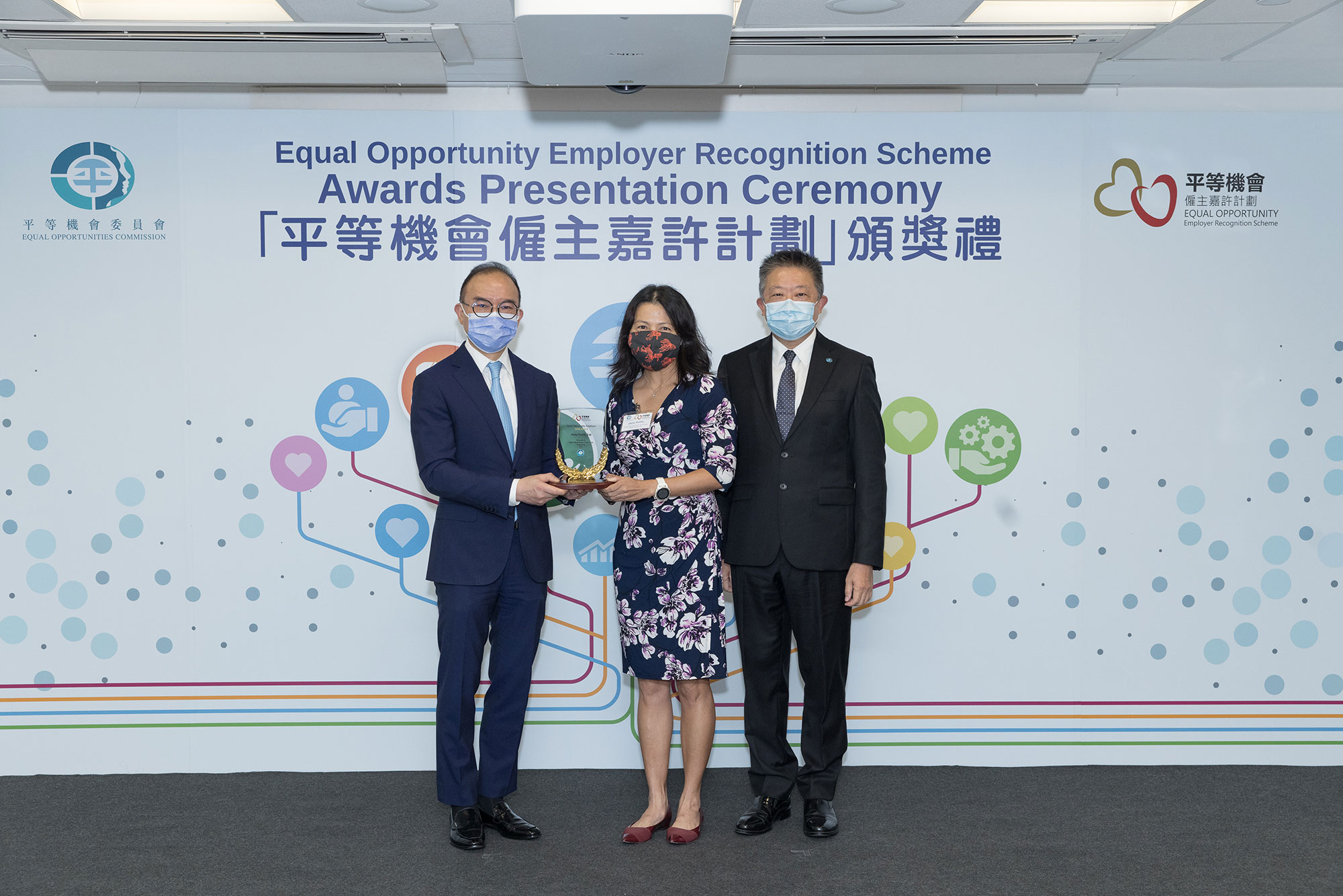 Mr Erick TSANG Kwok-wai, IDSM, JP, Secretary for Constitutional and Mainland Affairs (left) and Mr Ricky CHU Man-kin, IDS, Chairperson of the Equal Opportunities Commission (right), present the trophy to the representative of Swire Pacific Ltd (centre), winner of the Gold Award of the Equal Opportunity Employer Recognition Scheme.
